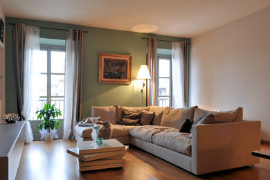 Ispirazione per un soggiorno minimalista di medie dimensioni e chiuso con pavimento in legno massello medio, TV a parete e pareti verdi