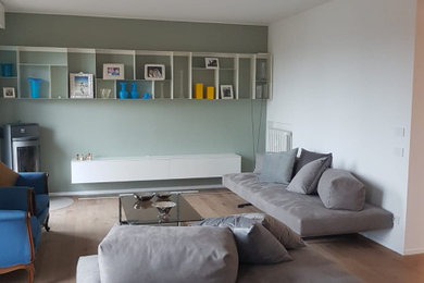 Immagine di un soggiorno minimal con pareti verdi e parquet chiaro