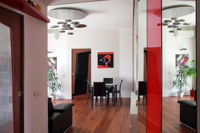 Foto di un soggiorno design con parquet scuro, pareti bianche, TV a parete e pavimento marrone