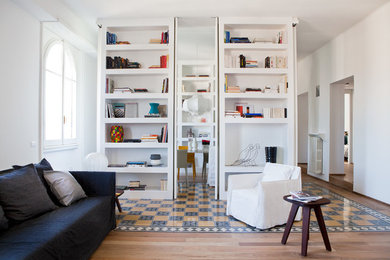 Diseño de biblioteca en casa abierta moderna de tamaño medio con paredes blancas, suelo multicolor y suelo de baldosas de cerámica
