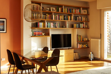 Immagine di un piccolo soggiorno moderno aperto con libreria, pareti arancioni, parquet scuro e pavimento marrone