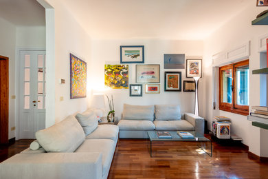 Mittelgroßes, Offenes Modernes Wohnzimmer mit weißer Wandfarbe, dunklem Holzboden und braunem Boden in Florenz