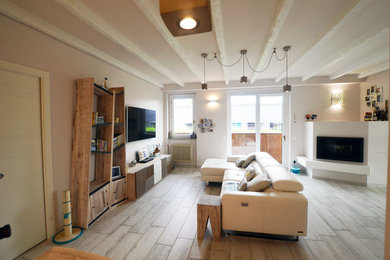 Großes, Offenes Shabby-Look Wohnzimmer mit beiger Wandfarbe, Porzellan-Bodenfliesen, Eckkamin, verputzter Kaminumrandung, TV-Wand und beigem Boden in Mailand