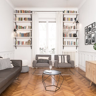 Ispirazione per un soggiorno nordico di medie dimensioni con libreria, TV a parete, pareti bianche, pavimento in legno massello medio e pavimento marrone