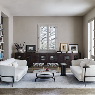 Esempio di un soggiorno moderno con nessuna TV, pareti beige, parquet chiaro e pavimento marrone