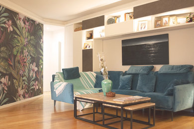 Imagen de biblioteca en casa abierta contemporánea de tamaño medio con paredes multicolor, suelo de madera clara, pared multimedia y suelo marrón