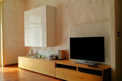 Foto de salón con rincón musical abierto minimalista de tamaño medio sin chimenea con suelo de madera clara, pared multimedia y paredes beige