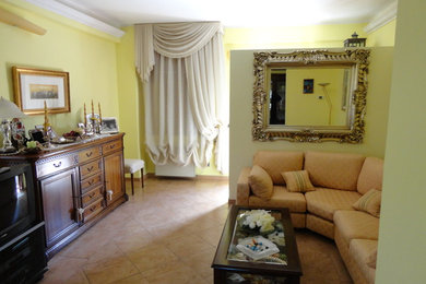 Foto de salón para visitas abierto de estilo de casa de campo de tamaño medio sin chimenea con paredes amarillas, suelo de baldosas de cerámica y pared multimedia