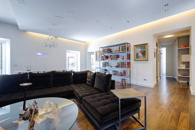 Modelo de salón abierto contemporáneo extra grande con suelo de madera oscura, televisor colgado en la pared y suelo marrón