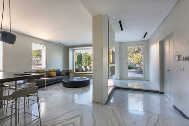 Источник вдохновения для домашнего уюта: двухуровневая гостиная комната среднего размера в стиле модернизм с белыми стенами, мраморным полом, двусторонним камином, фасадом камина из камня, скрытым телевизором и белым полом