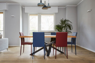Foto de comedor minimalista con paredes grises, suelo de madera en tonos medios y suelo marrón