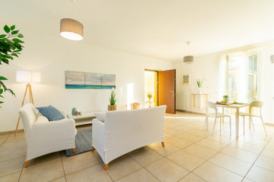 Imagen de salón abierto moderno grande con paredes blancas, suelo de baldosas de cerámica y suelo beige