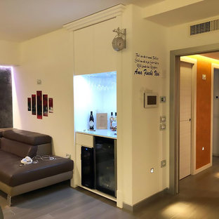 Esempio di un soggiorno minimal di medie dimensioni e aperto con angolo bar, pareti bianche, pavimento in gres porcellanato, TV a parete e pavimento marrone