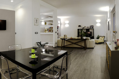 Esempio di un ampio soggiorno moderno aperto con pareti grigie, pavimento in gres porcellanato, TV a parete e pavimento grigio