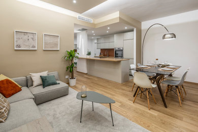 Idee per un soggiorno moderno con pareti beige, parquet chiaro e pavimento beige