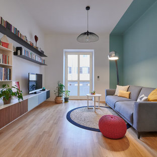 Foto di un soggiorno design con pareti blu, pavimento in legno massello medio, TV a parete e pavimento marrone
