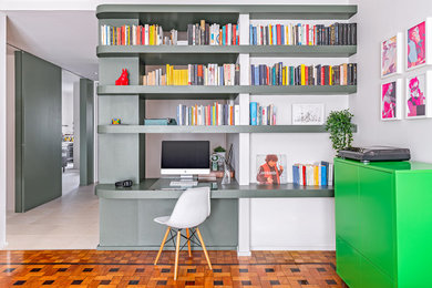 Esempio di un soggiorno design di medie dimensioni e aperto con libreria, pareti verdi, parquet scuro e pavimento marrone