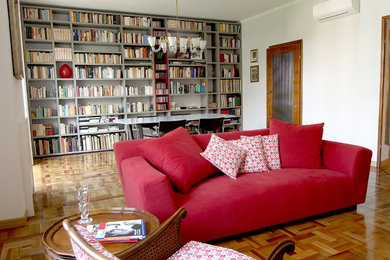 Diseño de biblioteca en casa abierta actual de tamaño medio con suelo marrón, paredes blancas y suelo de madera en tonos medios