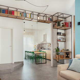 Esempio di un soggiorno industriale aperto con libreria, pareti blu, pavimento in gres porcellanato, pavimento grigio e nessun camino