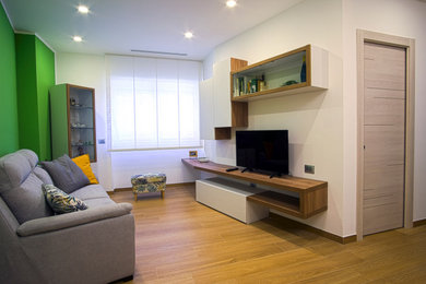 Inspiration pour une salle de séjour minimaliste ouverte avec un mur vert, un sol en carrelage de porcelaine, un téléviseur encastré et un sol marron.