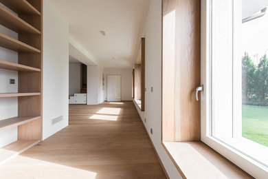 Immagine di un grande soggiorno nordico aperto con pareti bianche, parquet chiaro e pavimento marrone