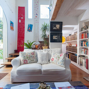 Idee per un soggiorno eclettico di medie dimensioni e aperto con libreria, pareti bianche, pavimento in legno massello medio e pavimento marrone