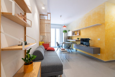 Modelo de salón cerrado contemporáneo pequeño con paredes amarillas, suelo de baldosas de porcelana y suelo gris