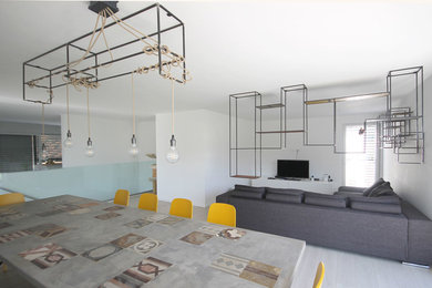 Idee per un soggiorno minimal di medie dimensioni e aperto con libreria, pareti bianche, pavimento in legno verniciato e TV autoportante