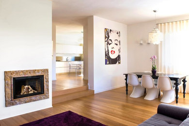 Photo of a contemporary open plan games room in Venice with white walls, light hardwood flooring, a standard fireplace and a stone fireplace surround.