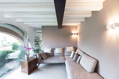 Esempio di un soggiorno moderno con pareti beige e pavimento in cemento