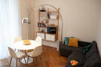 Imagen de salón abierto actual pequeño con paredes blancas, suelo de madera clara y pared multimedia