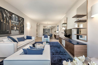 Ispirazione per un soggiorno design aperto con TV autoportante, pareti grigie, parquet chiaro, pavimento beige e tappeto