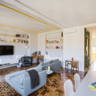 Foto di un grande soggiorno design aperto con TV a parete, pareti bianche, pavimento in legno massello medio e pavimento marrone