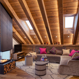 Idee per un soggiorno rustico aperto con pavimento in legno massello medio, camino bifacciale, cornice del camino in metallo e pavimento marrone