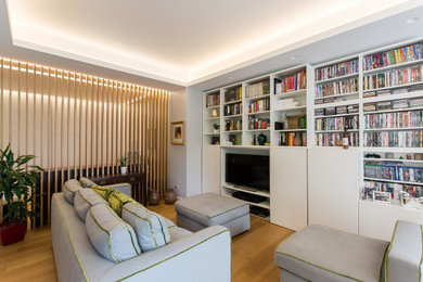 Immagine di un soggiorno design con pareti grigie e parquet chiaro