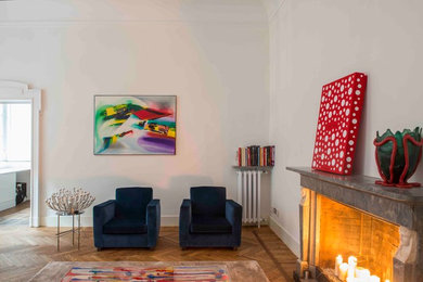 ミラノにあるコンテンポラリースタイルのおしゃれなリビング (白い壁、淡色無垢フローリング、標準型暖炉、石材の暖炉まわり、テレビなし、ベージュの床) の写真
