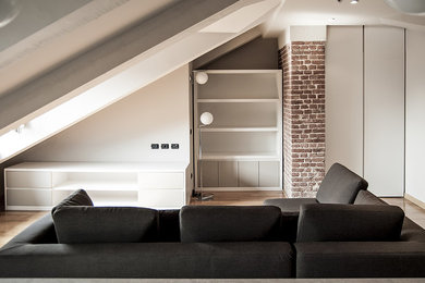 Foto di un soggiorno design di medie dimensioni e aperto con pareti bianche, parquet chiaro e libreria