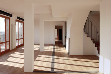 Foto de salón tipo loft contemporáneo de tamaño medio con paredes blancas y suelo de madera clara