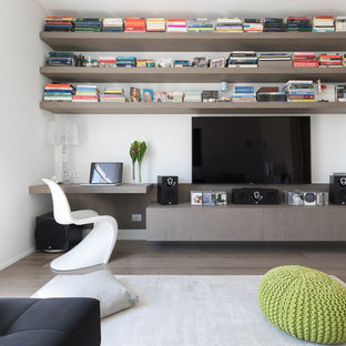 Foto di un soggiorno minimal con libreria, pareti bianche, parquet chiaro, TV a parete e pavimento beige