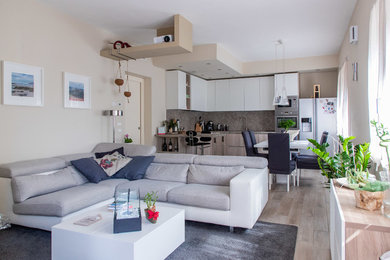 Idee per un soggiorno contemporaneo di medie dimensioni e chiuso con pareti beige, parquet chiaro, TV a parete e pavimento beige
