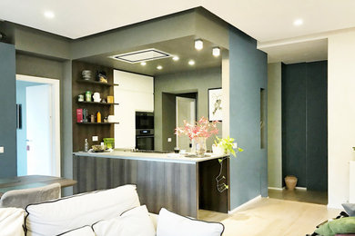 Ispirazione per un grande soggiorno design stile loft con pareti blu, parquet chiaro e TV a parete