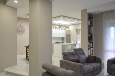 Esempio di un grande soggiorno moderno aperto con pareti beige, pavimento in gres porcellanato, TV a parete e pavimento grigio