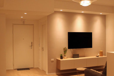 Foto di un soggiorno minimal di medie dimensioni con pareti bianche, pavimento in gres porcellanato e TV a parete
