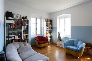 Immagine di un soggiorno mediterraneo di medie dimensioni e aperto con pareti blu, parquet chiaro e pavimento marrone