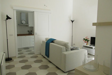 Immagine di un piccolo soggiorno design chiuso con pareti bianche, pavimento con piastrelle in ceramica, camino classico, cornice del camino in intonaco e pavimento beige
