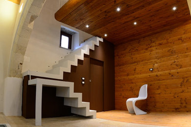 Diseño de salón tipo loft rústico pequeño con suelo de piedra caliza, todas las chimeneas y marco de chimenea de yeso