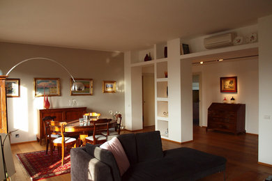 Immagine di un grande soggiorno moderno aperto con pareti beige e pavimento in legno massello medio