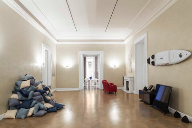 Esempio di un ampio soggiorno design con pareti beige, pavimento in legno massello medio, camino classico, cornice del camino in pietra e TV autoportante