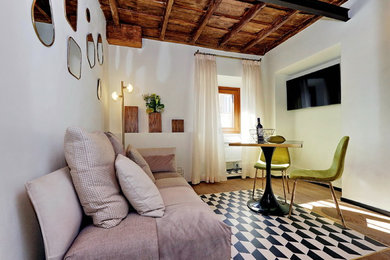 Imagen de salón tipo loft retro pequeño con paredes blancas, suelo de madera clara y televisor colgado en la pared
