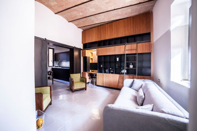 Immagine di un soggiorno design di medie dimensioni e chiuso con libreria, pareti grigie, pavimento in gres porcellanato, TV nascosta e pavimento grigio